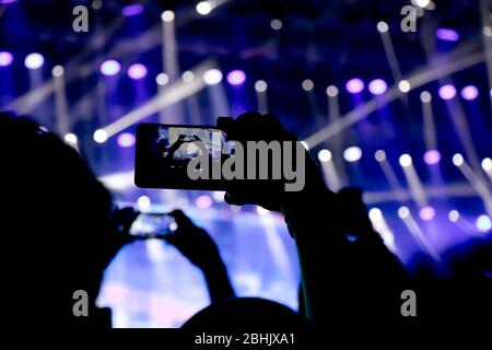Collecting digital memory is loosing capability of being present, silhouette of people hands shooting the concert with  smart phones Stock Photo