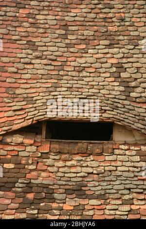 Eye-like air flow opening through the roof of traditional old house in Sibiu, Romania Stock Photo