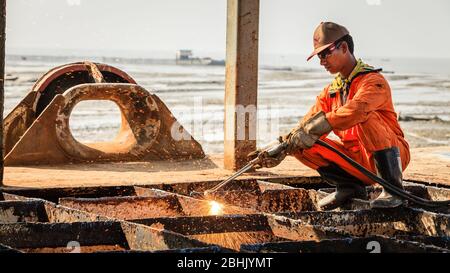 Chittagong, Bangladesh, December 23, 2017: A worker is cutting through metal deck structure of a ship at a ship-breaking yard in Chittagong, Banglades Stock Photo