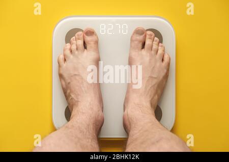 Bare feet stand on smart scales that makes bioelectric impedance analysis,  BIA, body fat measurement. Stock Photo by ©akoldunov 369502604