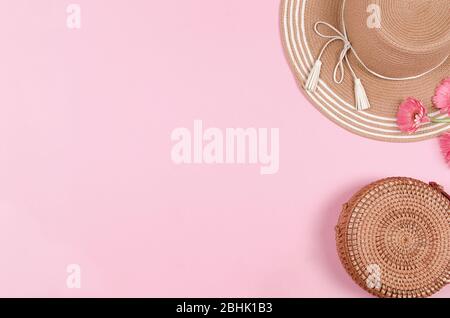 Summer straw hat, flower and straw bag on pink background.. top view, copy space. Stock Photo