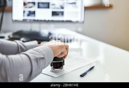 the man puts a seal on the document Stock Photo