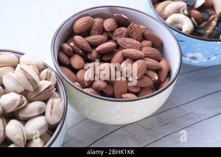 Mixed nuts in wooden bowls on wooden table . Stock Photo