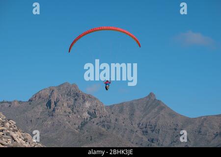 Paragliders pilot in the sky over mountains in Tenerife Stock Photo