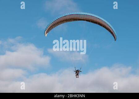 Paraglider with instructor pilot in tandem in the sky over Costa Adeje, Tenerife Stock Photo
