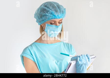 Young female doctor writing a medical report on a clipboard, healthcare professionals on white background. Healthcare concept Stock Photo