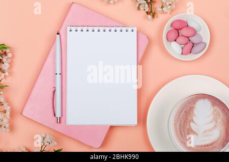 Creative flat lay of workspace desk, notepad for wishlist and lifestyle objects on pink background Stock Photo