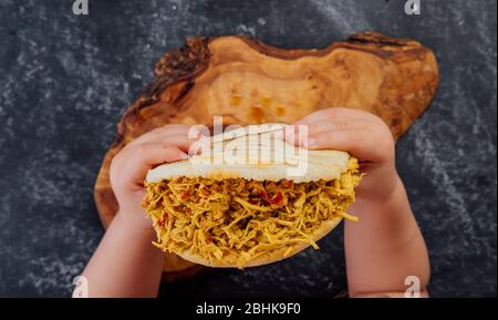 Boy holding an arepa, typical of Latin American cuisine. Stock Photo