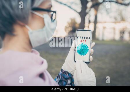 Senior woman using phone to get latest news on covid-19 Stock Photo