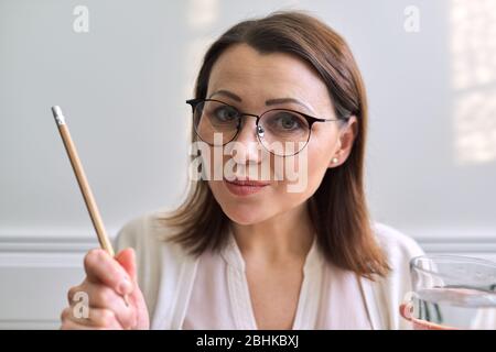 Female mentor, tutor, teacher looking at webcam, closeup face. Video conference, online lesson, teacher teaching remotely. Technology, education schoo Stock Photo