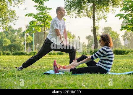 Mature couple doing sports exercises in park. Active healthy lifestyle, sport, fitness in middle-aged people Stock Photo