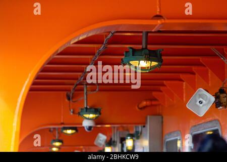 Bright ligjt lamp on orange red background, lamp on Staten island ferry Stock Photo