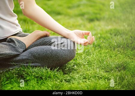 Cropped image of young woman meditating in the park. Stock Photo