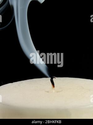Smoky wick of a extinguished paraffin candle isolated on a black background Stock Photo