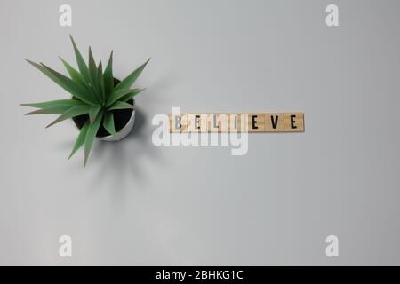 The word Believe written in wooden letter tiles on a white background.  Concept religion, business and inspiration. Stock Photo