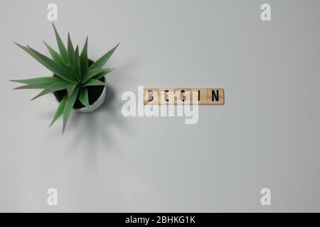 The word Begin written in wooden letter tiles on a white background.  Concept business, start and motivation. Stock Photo