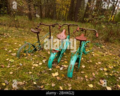 Abandoned residential area taken by nature. Left over bikes. Chernobyl Exclusion Zone. Ukraine Stock Photo