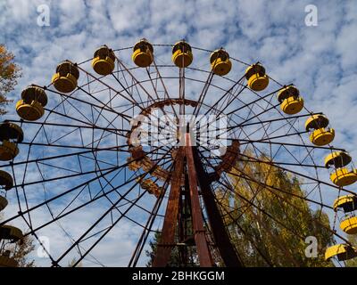 Ferris wheel in abandoned amusement park in ghost town Pripyat, post apocalyptic city, autumn season in Chernobyl exclusion zone, Ukraine Stock Photo