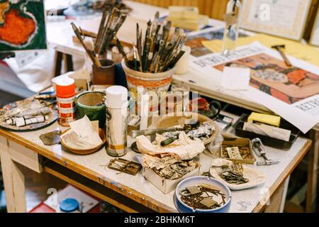 DUBROVNIK, CROATIA - 19 JUNE 2018: The artist's workshop. Paintings, brushes in the bank, sets of paints. Stock Photo