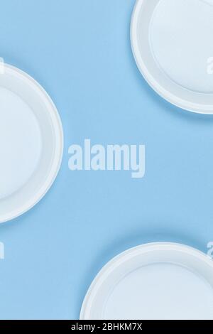Disposable plastic dishes, plates, blue background, copy space. For social media. Frame of objects. Environmental pollution, rejection of non-recyclab Stock Photo