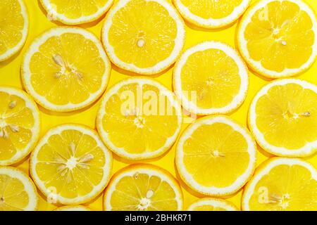 Lemon cut in half background. A slices of fresh yellow lemon pattern. Lemon pieces in different sizes. Stock Photo