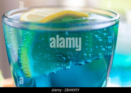 Blue lagoon cocktail. Lemon soda water in a glass, close up. Refreshing drink with ice. Stock Photo