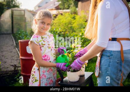 Young pretty woman with cute daughter in garden at summer happy smiling, lifestyle people concept Stock Photo