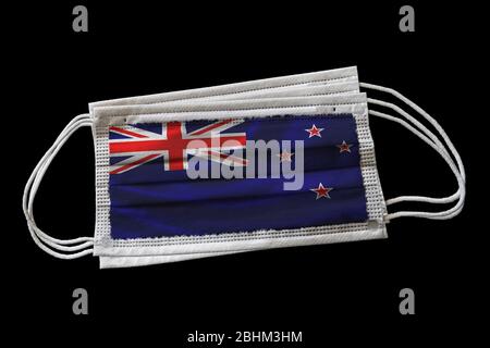 Multiple surgical face masks with New Zealand flag printed. Isolated on black background. Concept of face mask usage in the New Zealander effort to co Stock Photo