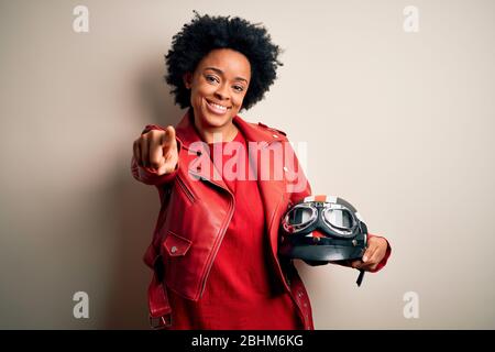 Young African American afro motorcyclist woman with curly hair drinking ...