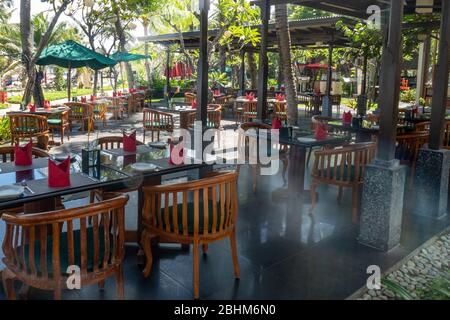 Tables and chairs set in the empty outdoor restaurant in  tropical resort Stock Photo