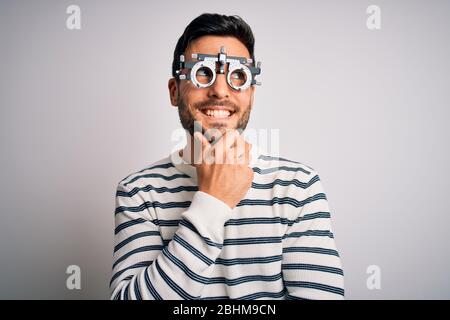 Young handsome man with beard wearing optometry glasses over isolated white background with hand on chin thinking about question, pensive expression. Stock Photo