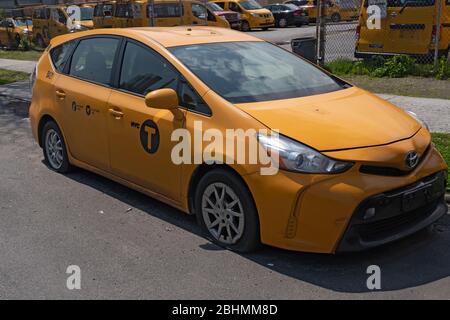 NEW YORK, NEW YORK - APRIL 25, 2020: Fleet of yellow taxi sits empty on parking lot as ridership and demand are down during the coronavirus pandemic. Stock Photo