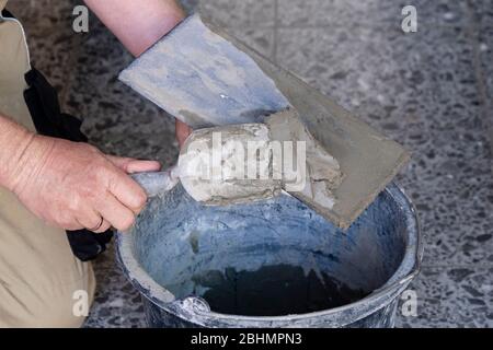 20 April 2020, Schleswig-Holstein, Lübeck: Putty is applied to a spatula for plastering. (to dpa 'Craftsmanship in times of Corona - not all trades suffer') Photo: Frank Molter/dpa Stock Photo