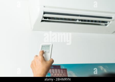 Remote control directed on air conditioner system, senior hand control air conditioner at home Stock Photo