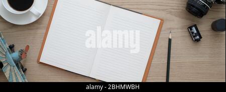 Overhead shot of comfortable workspace with open blank notebook, coffee cup camera and decoration on wooden desk Stock Photo
