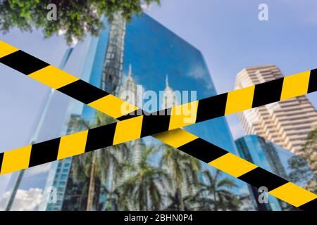 Kuala Lumpur reflected in the building Covid-19 quarantine yellow tape. Coronavirus or 2019-nCov virus Stock Photo