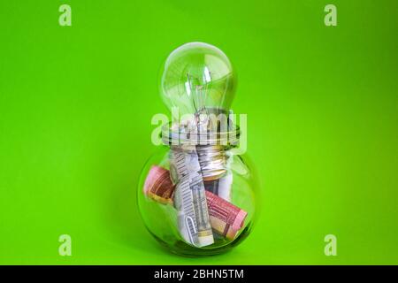 Money saved in different kinds of light bulbs, Lamps on the euro background Stock Photo