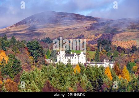 Clouds lifting over Blair Castle with mountain behind in Blair Atholl Perthshire Scotland on a sunny autumn day as seen from the A9 road Stock Photo