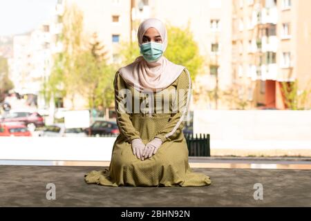 Young Muslim Woman Praying in Mosque With Surgical Mask and Gloves Stock Photo