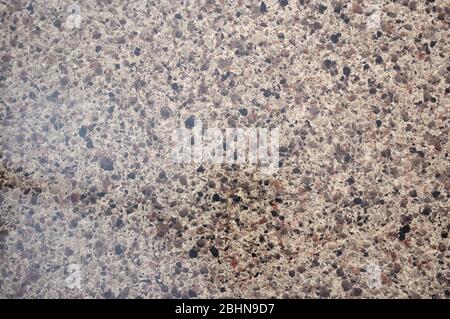 Light brown granite, rich pattern with black splashes of natural polished stone close-up. Background, texture. Stock Photo