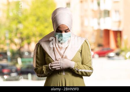 Young Muslim Woman Praying in Mosque With Surgical Mask and Gloves Stock Photo