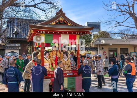 tokyo, japan - march 18 2020: Yatai cart overlooked by a buddhist temple's roof in which sit the Matsuri-bayashi music musicians played using the taik Stock Photo