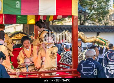 tokyo, japan - march 18 2020: Yatai cart overlooked by a buddhist temple's roof in which sit the Matsuri-bayashi music musicians played using the taik Stock Photo