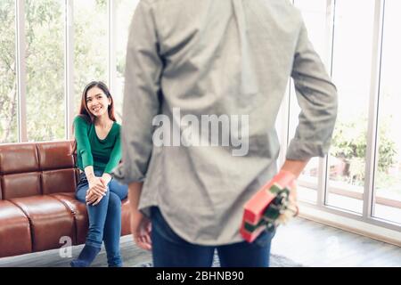 Romantic Surprise and Couple Love Valentine Concept, Young Man is Presenting Surprised to His Girlfriend at Home. Beautiful Woman Having Happiness and Stock Photo