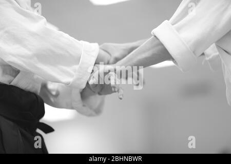 Sensei shows a student the technique of grabbing hands in aikido school Stock Photo