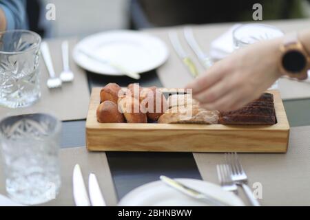 Tray with white and black bread and rolls on a served table in a restaurant Stock Photo