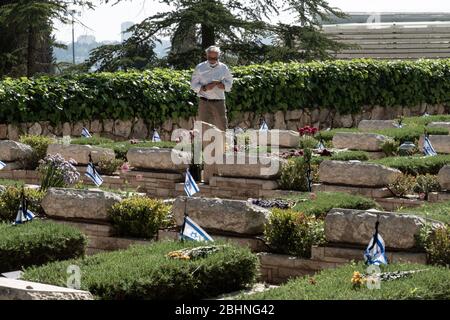 Jerusalem, Israel. 27th Apr, 2020. Families visit the graves of the fallen at the Mt. Herzl Military Cemetery ahead of Memorial Day, to be commemorated 28th April, 2020. Military Cemeteries will close today at 14:00 as government will impose a total lockdown nationwide on Memorial Day and the following Independence Day in an attempt to further curb COVID-19 spread. Credit: Nir Alon/Alamy Live News
