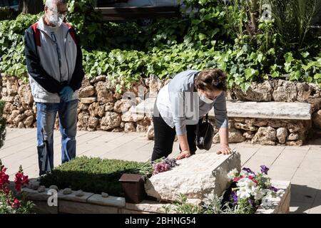 Jerusalem, Israel. 27th Apr, 2020. Rebecca mourns her brother Yehuda Ben Arush, killed in Bethlehem in 1997 while in IDF reserve duty, 35, married and the father of two. Families visit the graves of the fallen at the Mt. Herzl Military Cemetery ahead of Memorial Day, to be commemorated 28th April, 2020. Military Cemeteries will close today at 14:00 as government will impose a total lockdown nationwide on Memorial Day and the following Independence Day in an attempt to further curb COVID-19 spread. Credit: Nir Alon/Alamy Live News