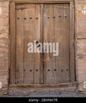 Wooden door with decoration in a house in the centre of the old town of Khiva in Uzbekistan. Stock Photo