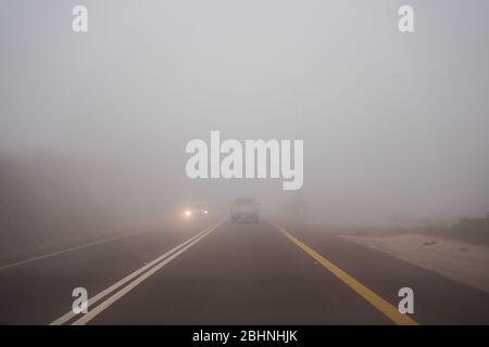Car and truck driving in dense fog in the mountains near Abha, Saudi Arabia Stock Photo